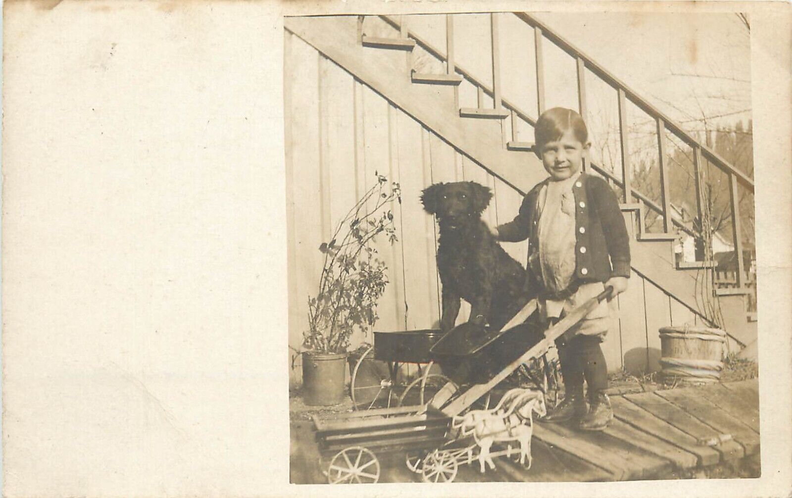 c1907 RPPC Little Boy & His Black Dog in Wagon, with Some of His Toys, Unposted