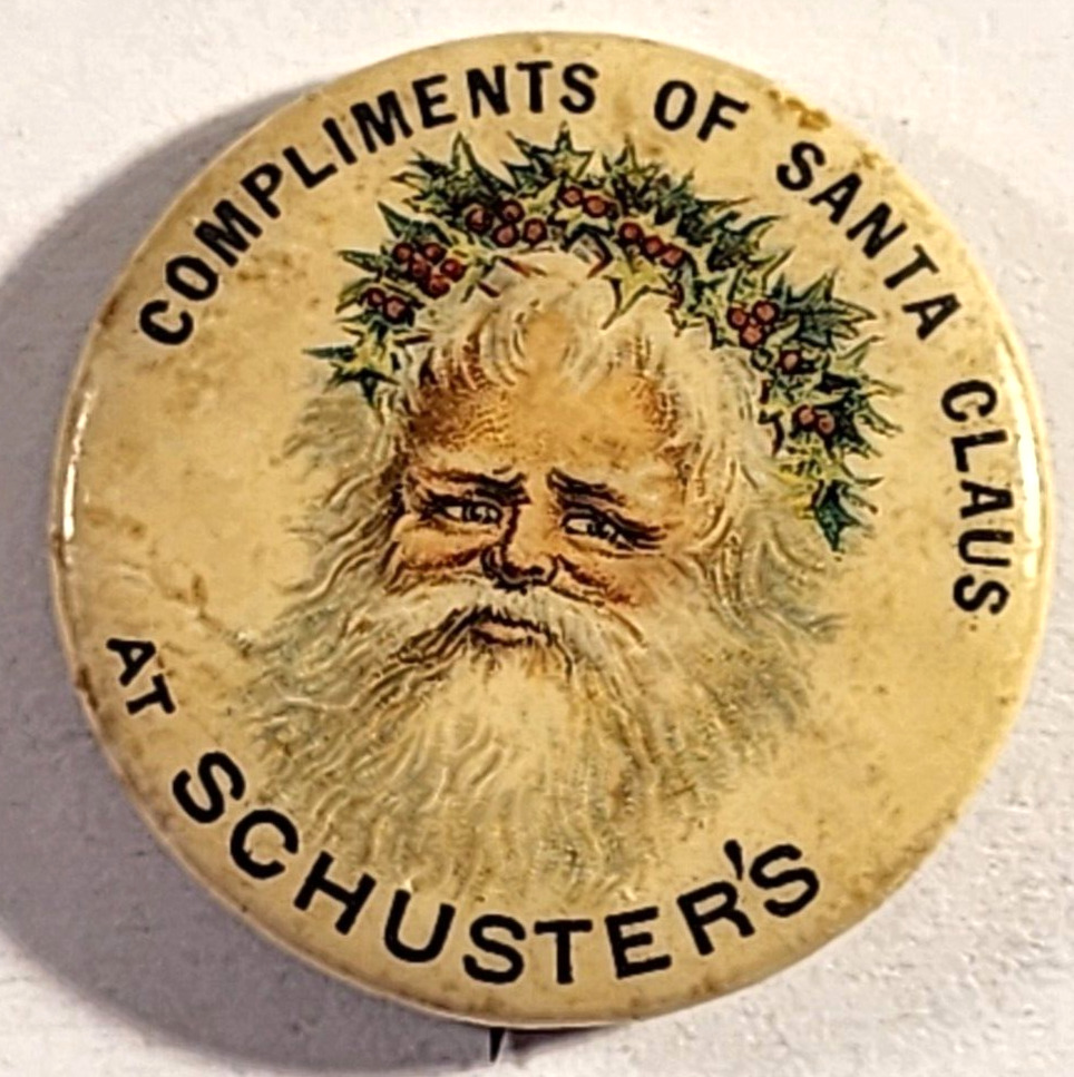 ANTIQUE 1896 COMPLIMENTS OF SANTA CLAUS AT SCHUSTER'S PINBACK BUTON