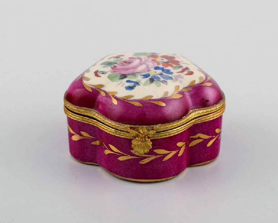 Antique lidded box in hand-painted porcelain with flowers and gold decoration.
