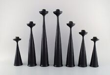 A collection of seven Scandinavian designer candlesticks in wood and brass. picture