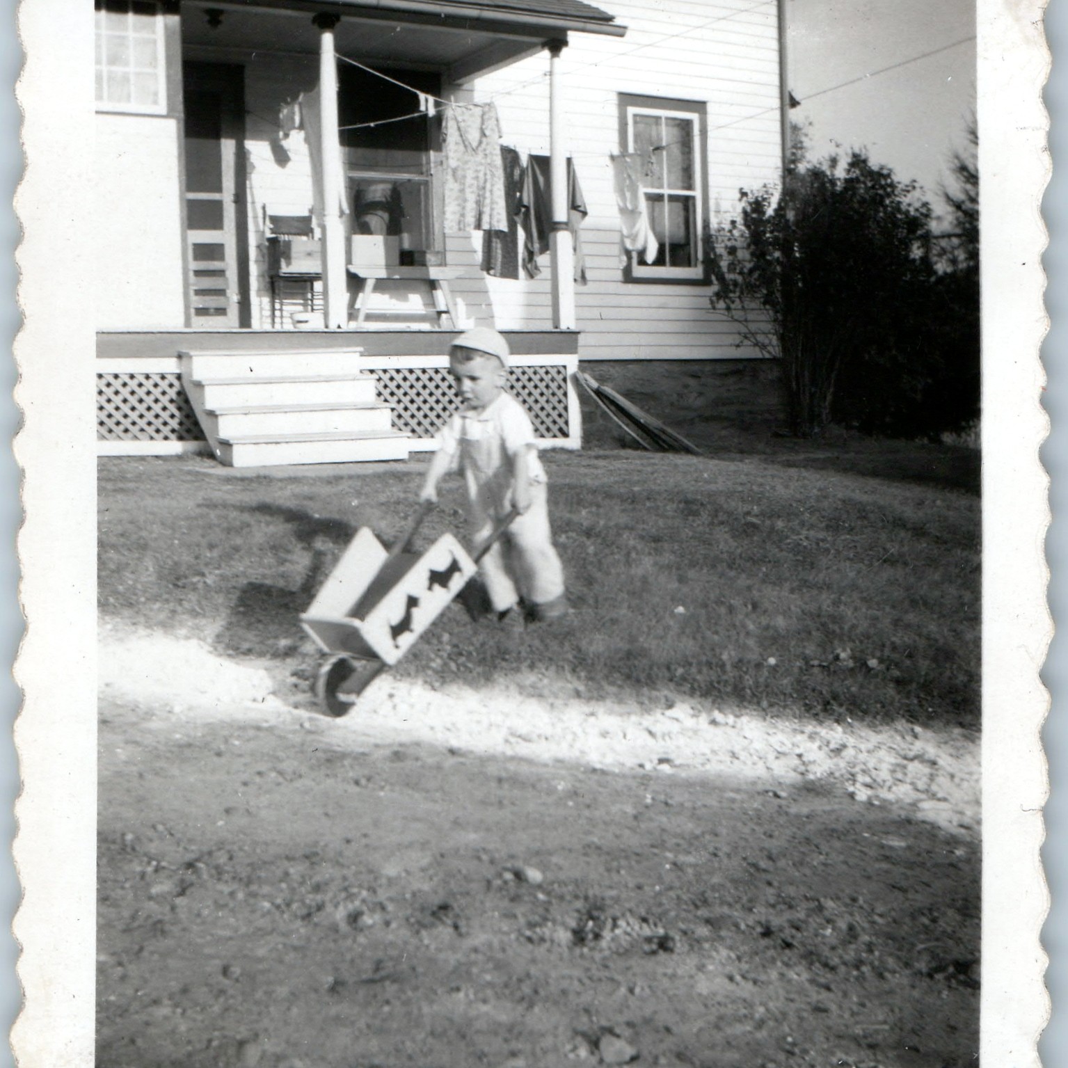 c1940s Young Boy Toy Wheelbarrow Snapshot Photo House Porch Laundry Line Velox c1940s Young Boy Toy Wheelbarrow Snapshot Photo House Porch Laundry Line Velox