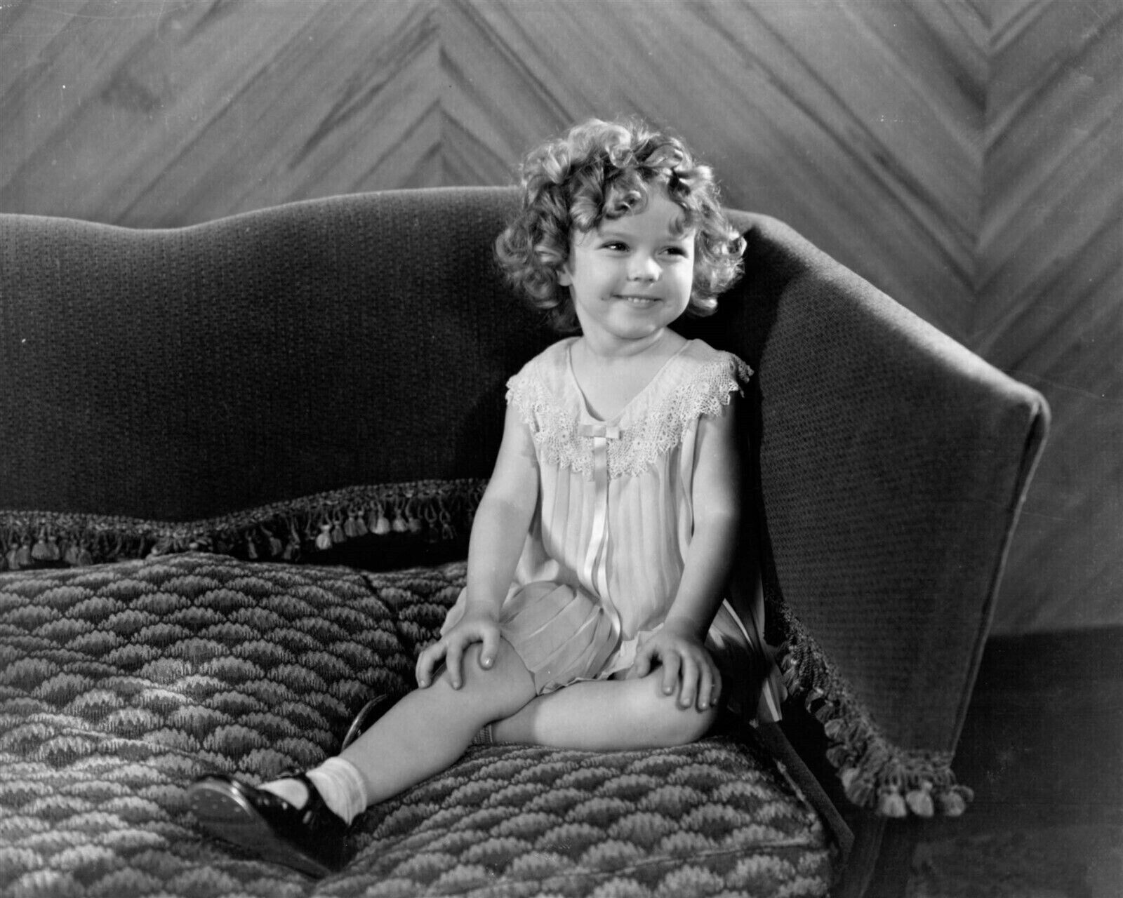 Shirley Temple sits on sofa smiling sweetly 4x6 inch photo